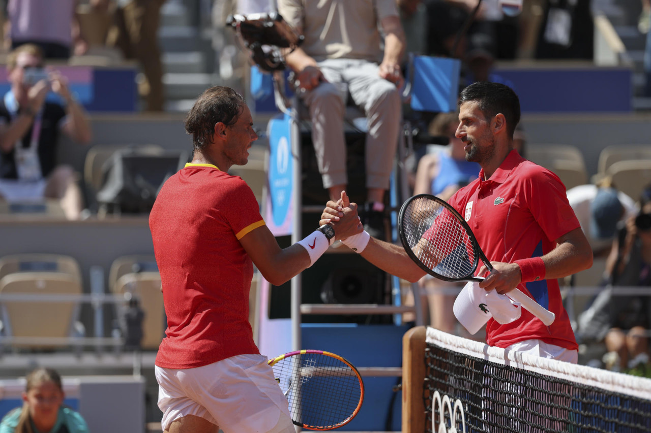 El tenista español Rafa Nadal (i) se despide del serbio Novak Djokovic tras perder en su partido celebrado en el marco de los Juegos Olímpicos de París, este lunes. EFE/ Juanjo Martín.